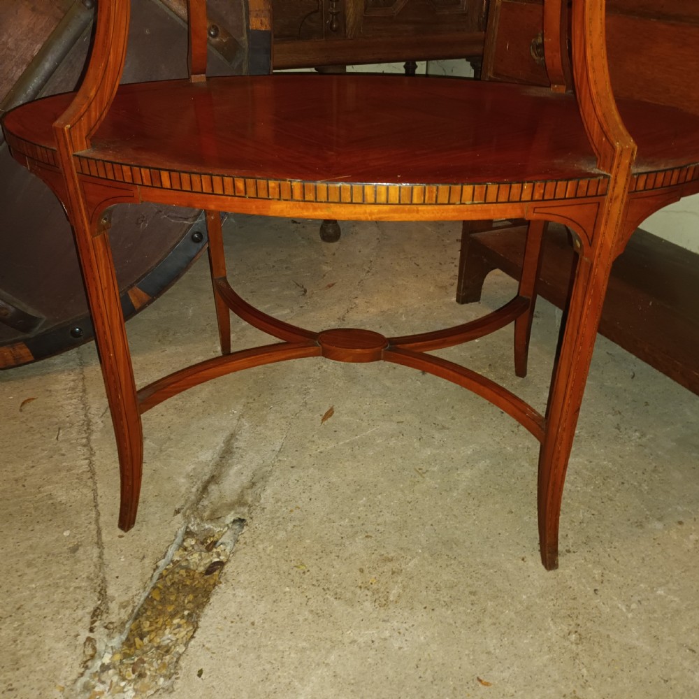 An Edwardian oval two-tier satinwood etagere side table with diamond-matched wood veneer and swept legs. View VI