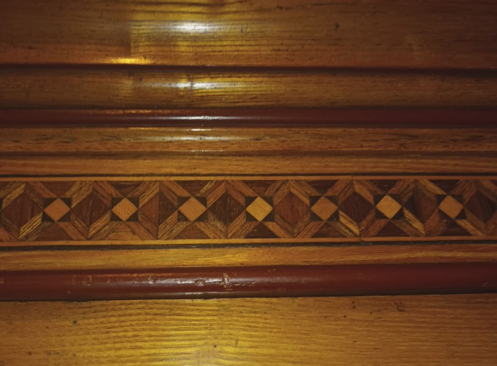 A large Victorian triple-door ash wardrobe featuring geometric marquetry inlay panels, a central mirrored door, and a heavily moulded upper cornice. View XXIV