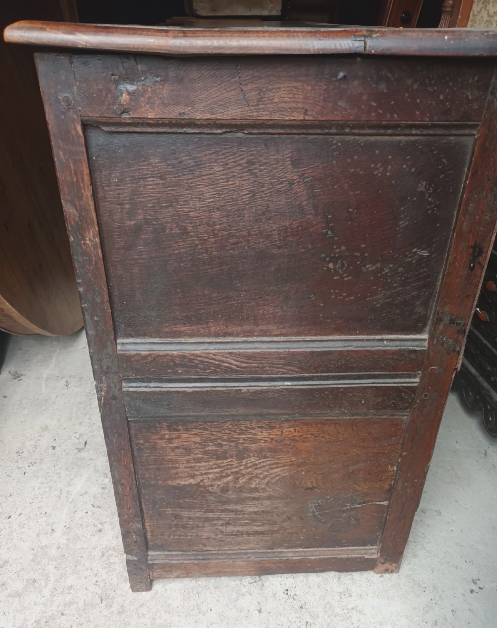 An antique two-part dark oak Welsh dresser featuring an upper plate rack with open shelves over a base cabinet with drawers and geometric panelled doors. View IX