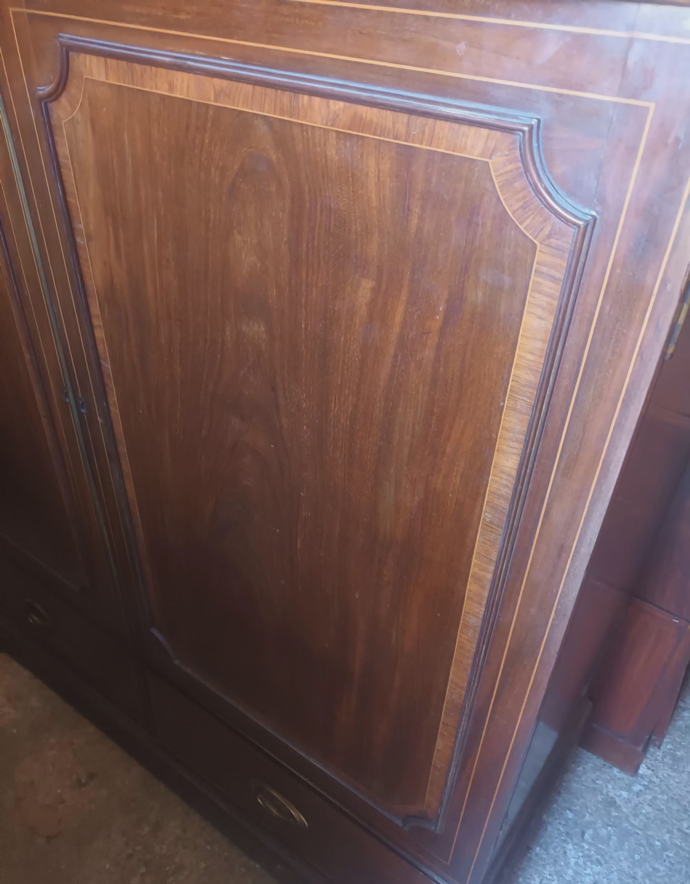 A warm brown mahogany dwarf linen press cupboard featuring two crossbanded cupboard doors above two lower drawers with brass handles. View XIII