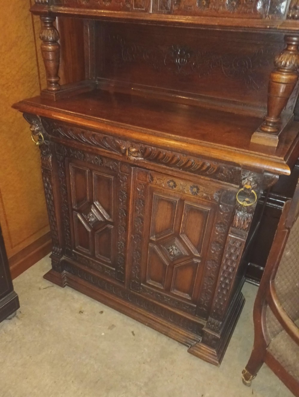 A dark Victorian carved oak bookcase with upper leaded glass doors, middle turned supports, and relief-carved lower panel doors. View VIII