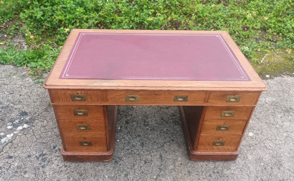 Late Victorian oak kneehole pedestal desk with campaign style handles. View II