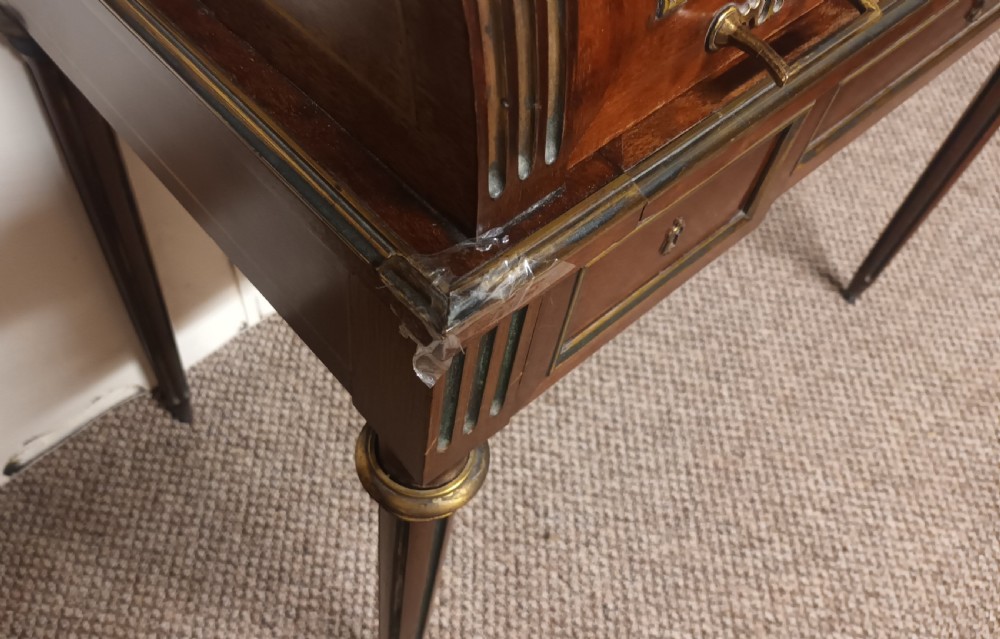 An antique French mahogany cylinder bureau featuring brass mouldings, a top pierced brass gallery, frieze drawers, and fluted legs. View VIII