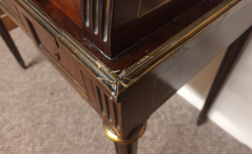 An antique French mahogany cylinder bureau featuring brass mouldings, a top pierced brass gallery, frieze drawers, and fluted legs. View IX