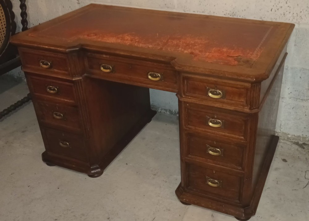 Late Victorian oak kneehole pedestal desk with side slides.