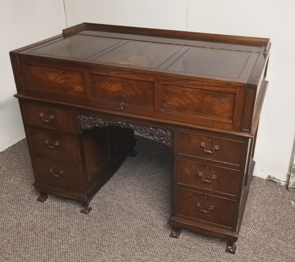 An Edwardian dark mahogany kneehole writing desk featuring a fitted upper superstructure, leather writing surface, twin drawer pedestals, brass handles, and claw feet. View II