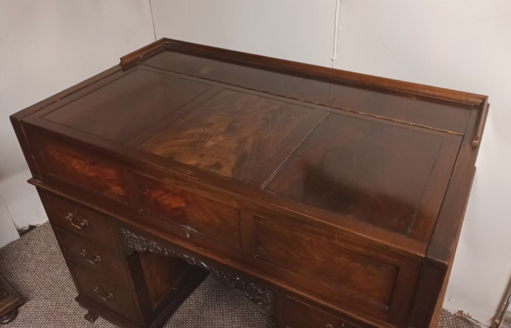 An Edwardian dark mahogany kneehole writing desk featuring a fitted upper superstructure, leather writing surface, twin drawer pedestals, brass handles, and claw feet. View VII