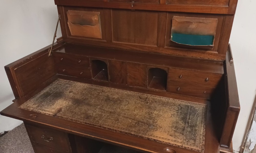 An Edwardian dark mahogany kneehole writing desk featuring a fitted upper superstructure, leather writing surface, twin drawer pedestals, brass handles, and claw feet. View XII