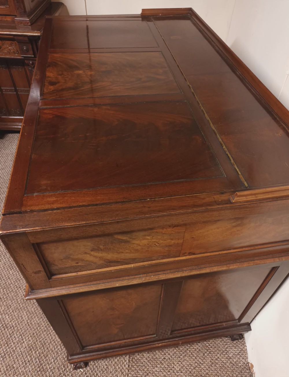 An Edwardian dark mahogany kneehole writing desk featuring a fitted upper superstructure, leather writing surface, twin drawer pedestals, brass handles, and claw feet. View XVII