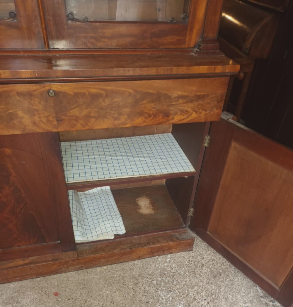 A tall 19th-century mahogany library bookcase featuring two upper glazed doors over a two-door cupboard base with flame mahogany veneer panels. View VII