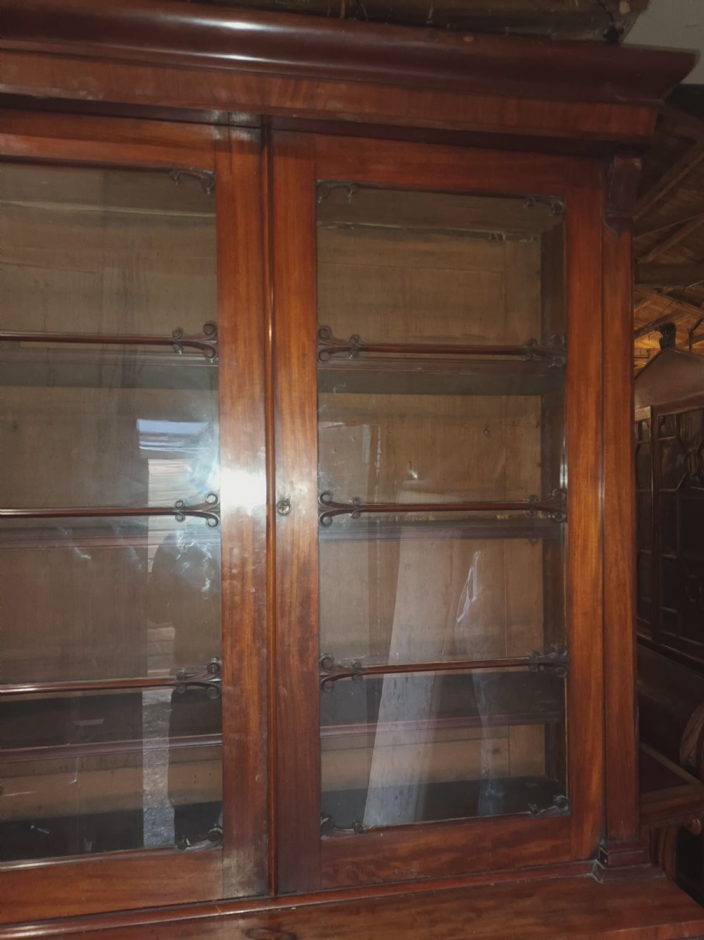 A tall 19th-century mahogany library bookcase featuring two upper glazed doors over a two-door cupboard base with flame mahogany veneer panels. View X