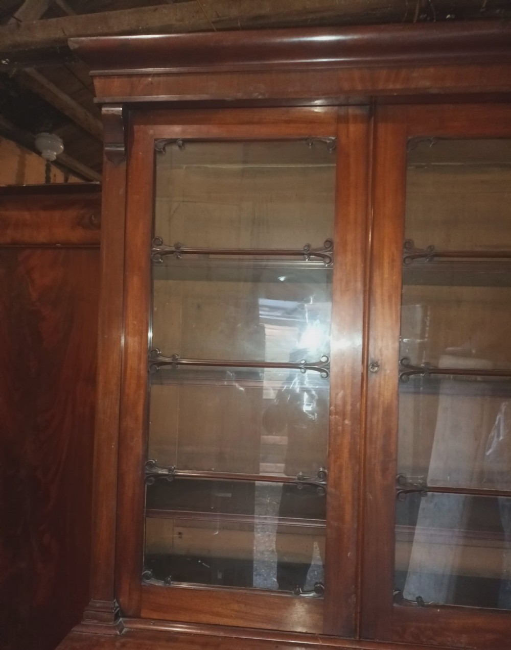 A tall 19th-century mahogany library bookcase featuring two upper glazed doors over a two-door cupboard base with flame mahogany veneer panels. View XI
