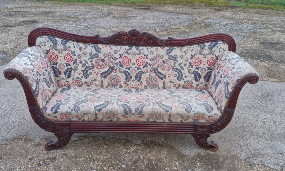 An early Victorian carved mahogany sofa with scroll arms and cream floral patterned upholstery. View III