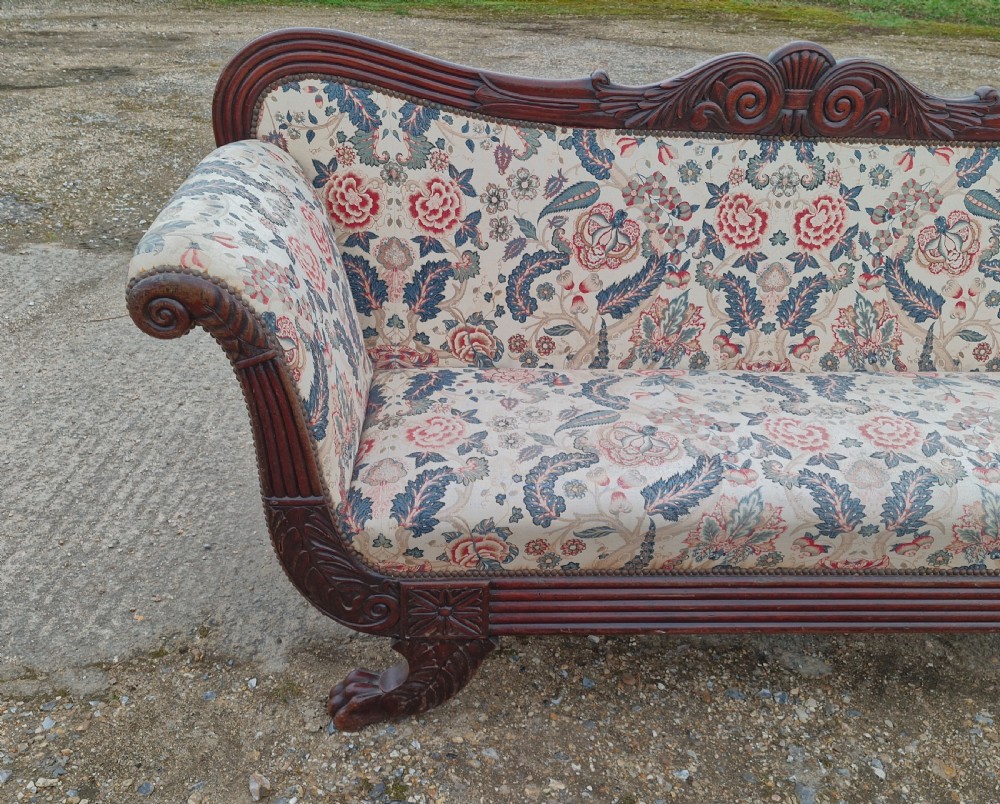 An early Victorian carved mahogany sofa with scroll arms and cream floral patterned upholstery. View VII