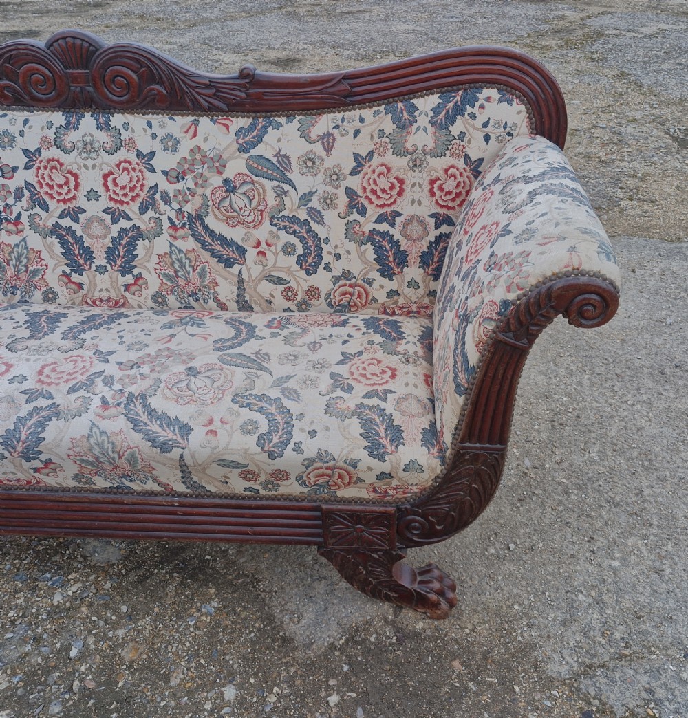 An early Victorian carved mahogany sofa with scroll arms and cream floral patterned upholstery. View VIII