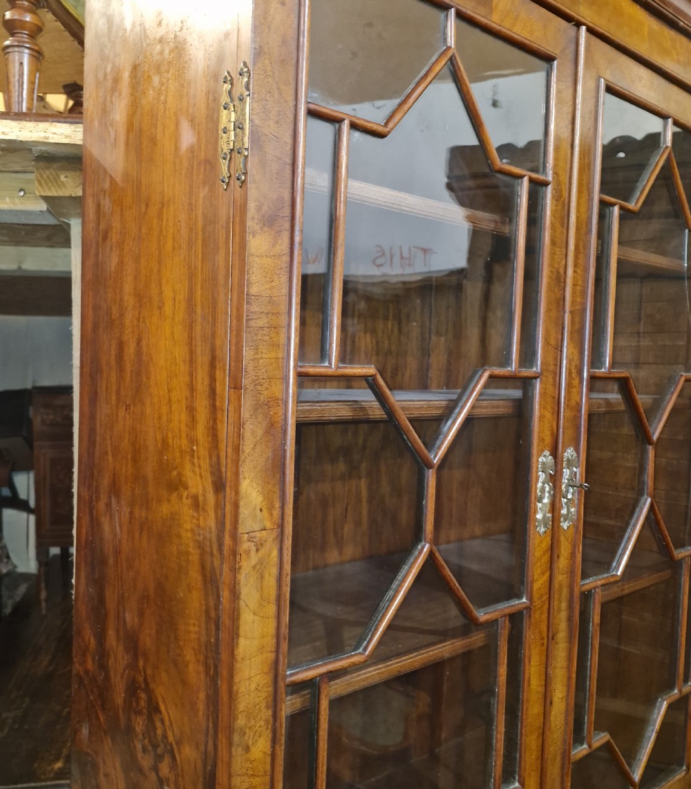 An antique walnut bureau bookcase featuring astragal glazed upper doors, a slant-front writing desk, and lower drawers on bracket feet. View XVII