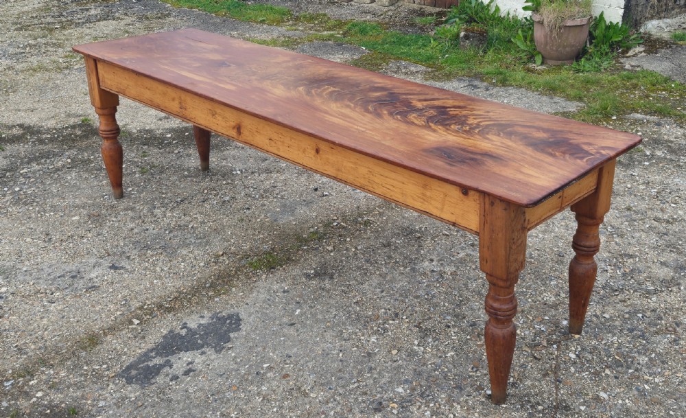 A long Victorian pine kitchen dining table featuring a single-board top with visible wood grain and four turned legs. View VII