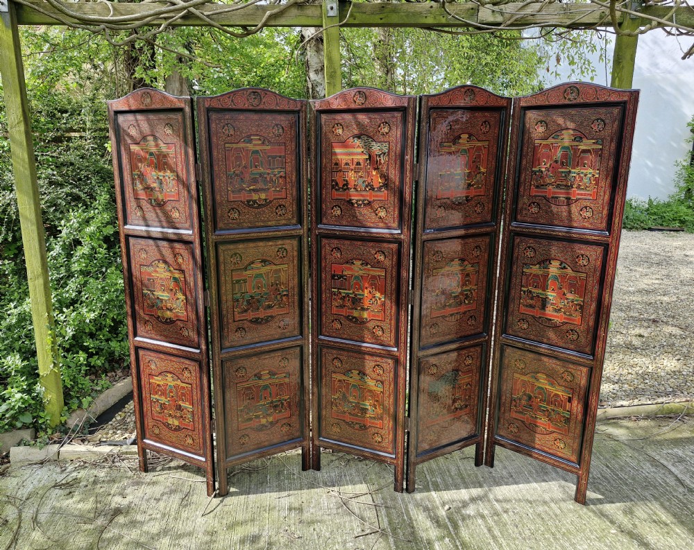 A five-panel Burmese folding screen decorated with red and black lacquered panels depicting detailed architectural scenes. View VII