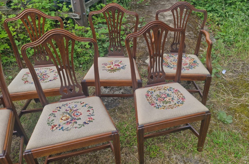 A set of eight dark mahogany dining chairs featuring carved pierced back splats and floral needlework drop-in seats. View III