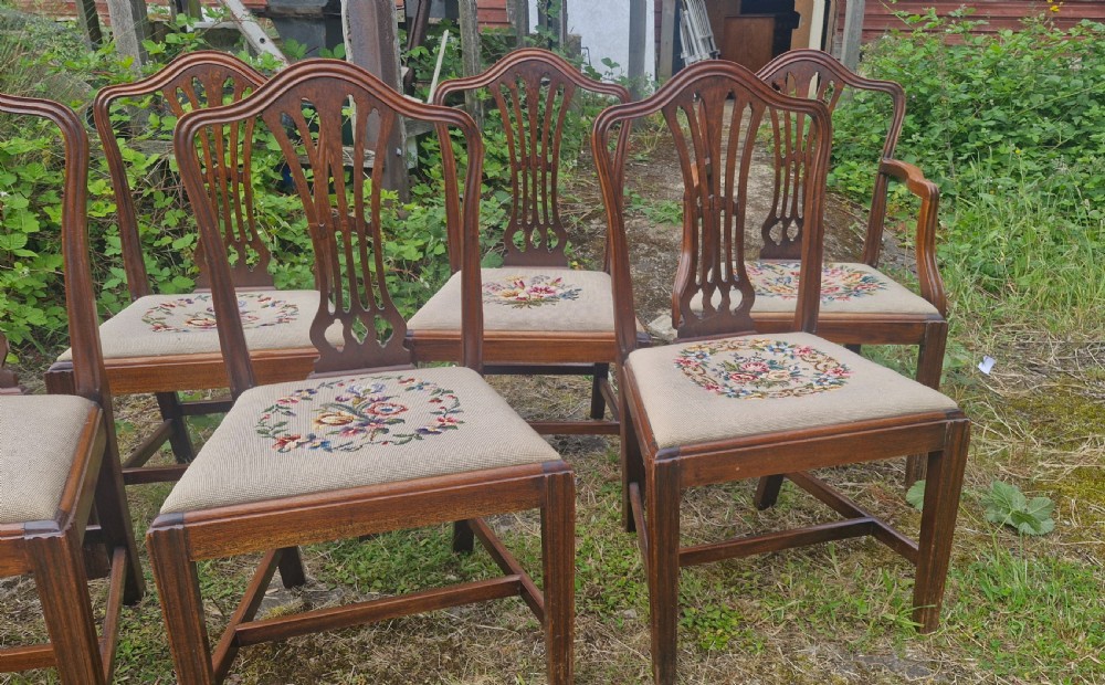 A set of eight dark mahogany dining chairs featuring carved pierced back splats and floral needlework drop-in seats. View IV