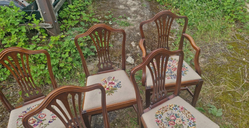 A set of eight dark mahogany dining chairs featuring carved pierced back splats and floral needlework drop-in seats. View VIII