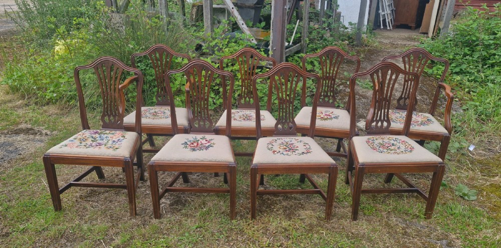 A set of eight dark mahogany dining chairs featuring carved pierced back splats and floral needlework drop-in seats. View IX