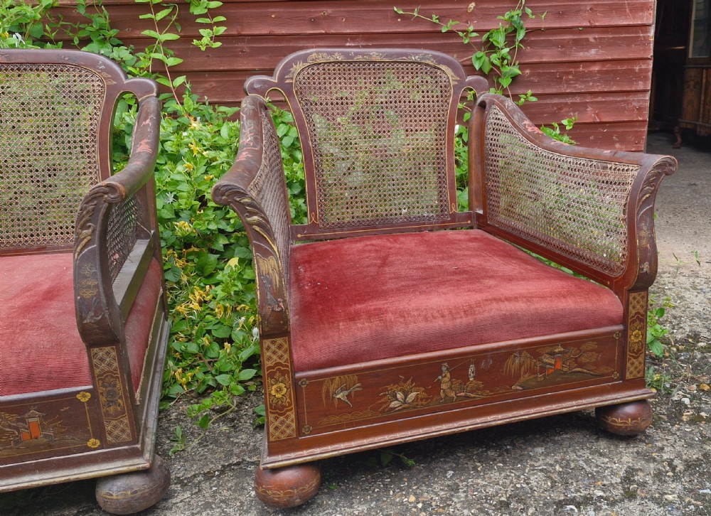 A set of three low-built chinoiserie bergere armchairs featuring hand-painted lacquered frames, woven cane backs and sides, and red velvet seats. View II