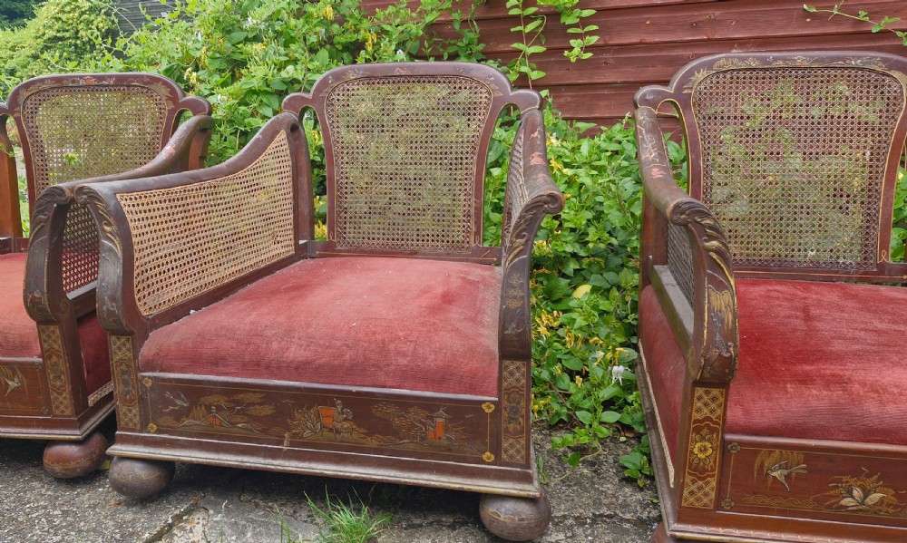 A set of three low-built chinoiserie bergere armchairs featuring hand-painted lacquered frames, woven cane backs and sides, and red velvet seats. View III