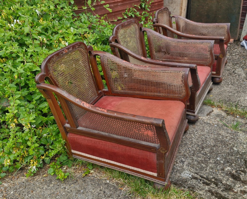 A set of three low-built chinoiserie bergere armchairs featuring hand-painted lacquered frames, woven cane backs and sides, and red velvet seats. View VIII