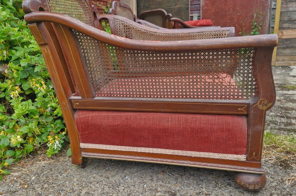 A set of three low-built chinoiserie bergere armchairs featuring hand-painted lacquered frames, woven cane backs and sides, and red velvet seats. View XIII