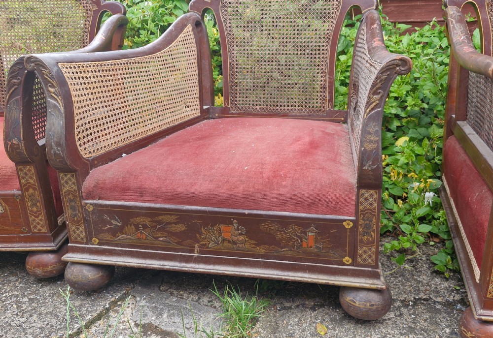 A set of three low-built chinoiserie bergere armchairs featuring hand-painted lacquered frames, woven cane backs and sides, and red velvet seats. View XV