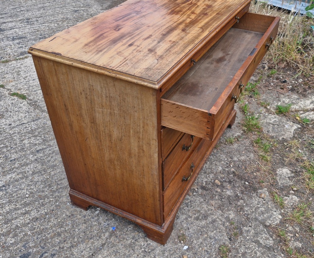 An early nineteenth-century mahogany chest of four graduated drawers featuring brass swan-neck handles, key escutcheons, a pull-out brushing slide, and bracket feet. View III