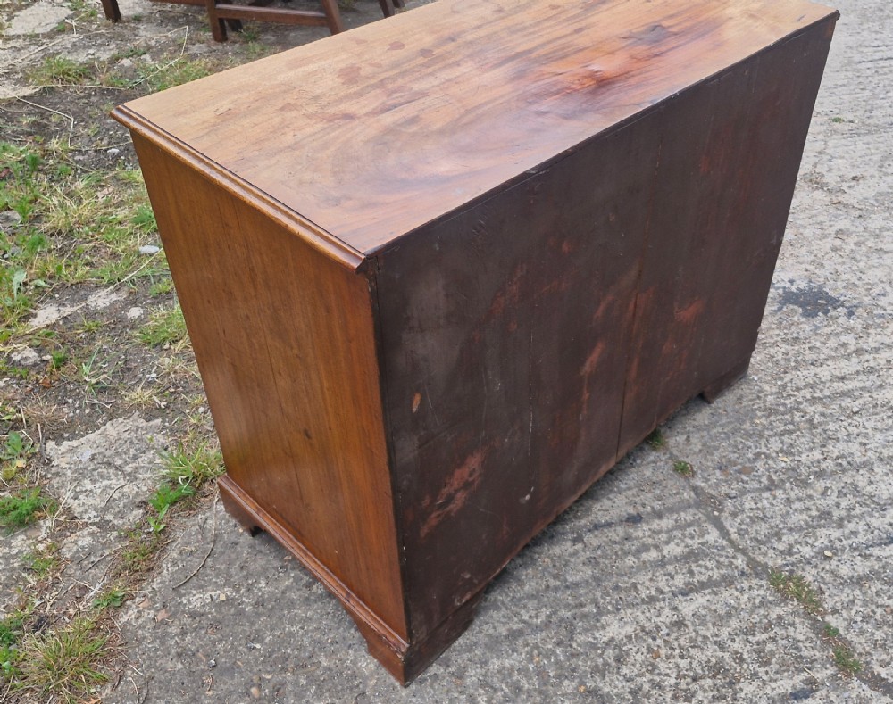 An early nineteenth-century mahogany chest of four graduated drawers featuring brass swan-neck handles, key escutcheons, a pull-out brushing slide, and bracket feet. View V