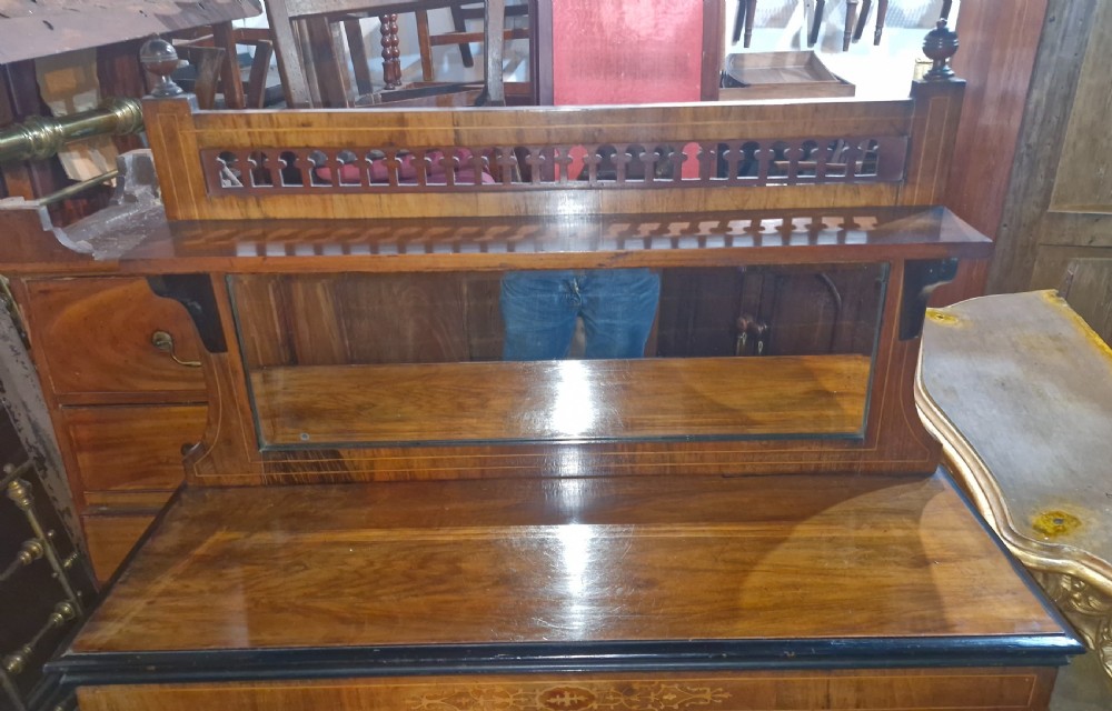 A Victorian walnut side cabinet featuring two glazed doors, decorative marquetry inlay, brass mounts, and an upper gallery shelf with an inset mirror. View VI