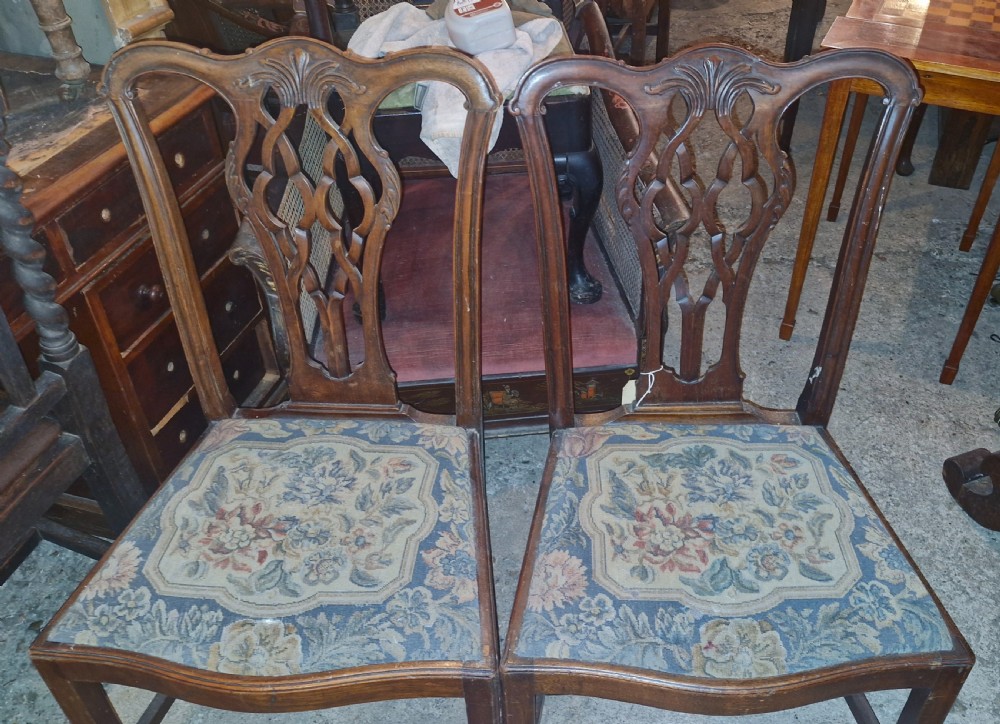 A pair of carved mahogany side chairs featuring openwork pierced splats and floral tapestry upholstered drop-in seats. View II