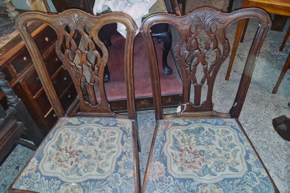 A pair of carved mahogany side chairs featuring openwork pierced splats and floral tapestry upholstered drop-in seats. View IV