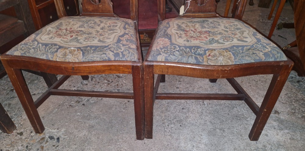 A pair of carved mahogany side chairs featuring openwork pierced splats and floral tapestry upholstered drop-in seats. View V