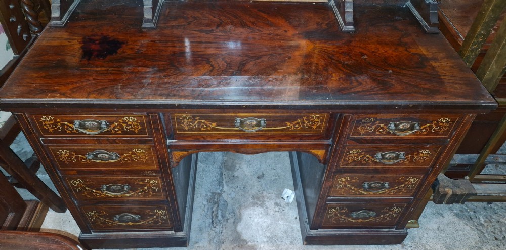 A late Victorian dark rosewood dressing table featuring classical bone and satinwood marquetry, a central swing mirror, raised trinket drawers, and twin pedestal storage. View V