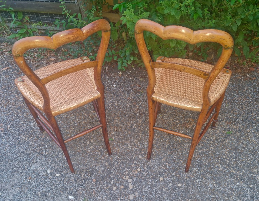 A pair of Victorian side chairs featuring light brown wooden frames adorned with hand-painted floral motifs and woven cane seats. View IV