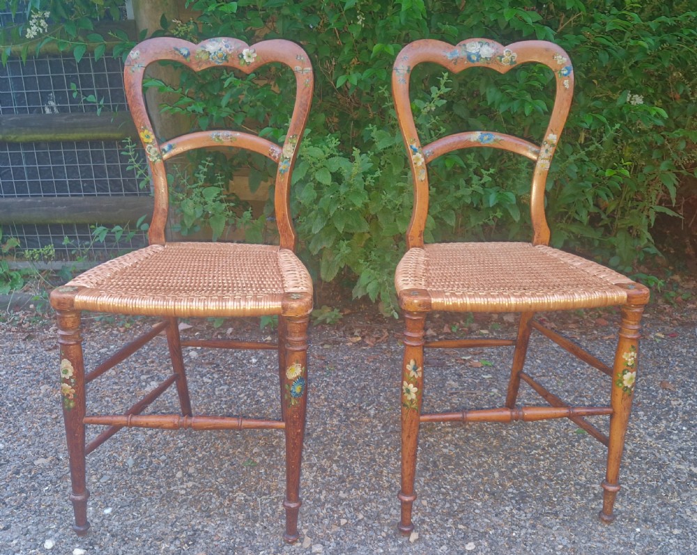 A pair of Victorian side chairs featuring light brown wooden frames adorned with hand-painted floral motifs and woven cane seats. View IX