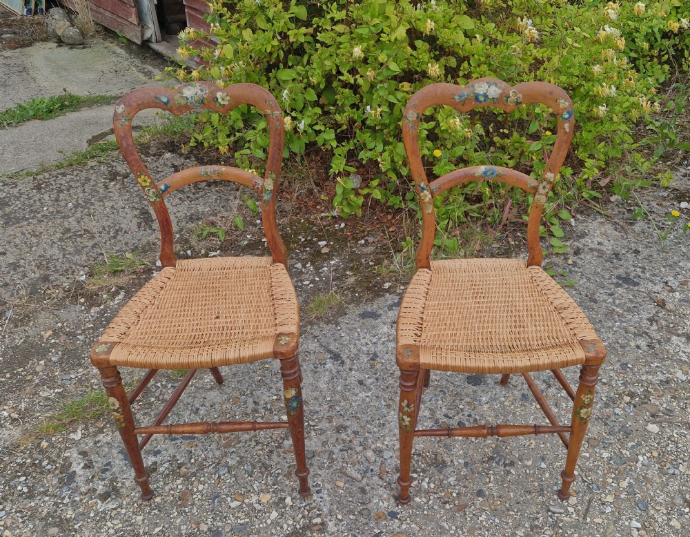 A pair of Victorian side chairs featuring light brown wooden frames adorned with hand-painted floral motifs and woven cane seats. View XII