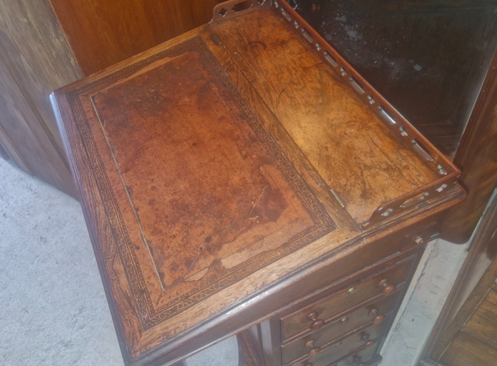 A Regency rosewood Davenport desk featuring a sloped leather writing surface, gallery top, spiral support columns, and side drawers. View X