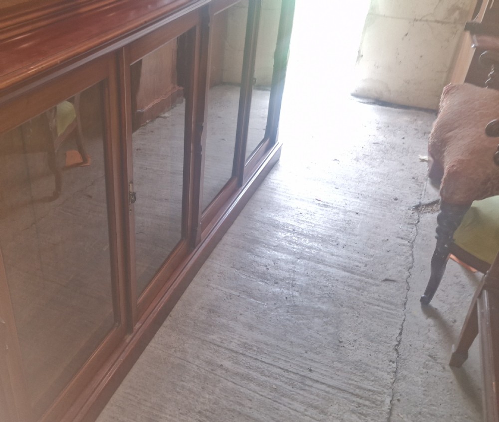 A large late Victorian mahogany low bookcase featuring four glazed glass doors with removable timber shelves resting in front. View III