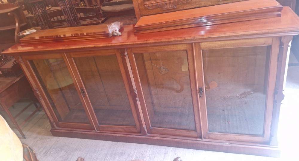 A large late Victorian mahogany low bookcase featuring four glazed glass doors with removable timber shelves resting in front. View XVIII