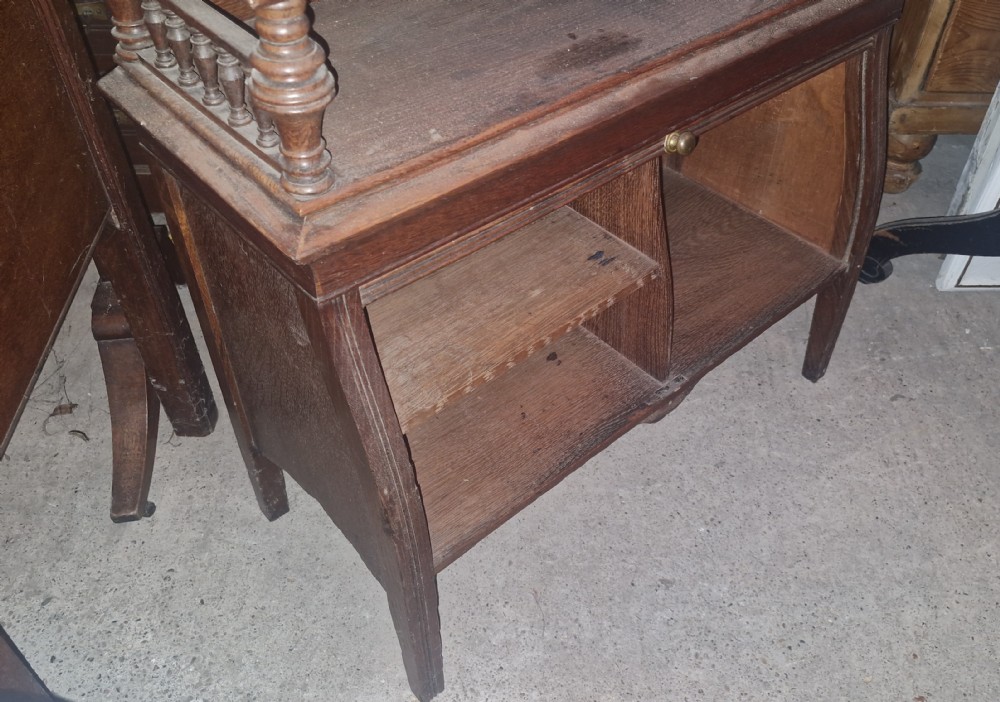 A late Victorian dark oak writing bureau featuring a pierced carved top gallery, fall-front drop lid with brass hardware, and a lower tambour door compartment. View X