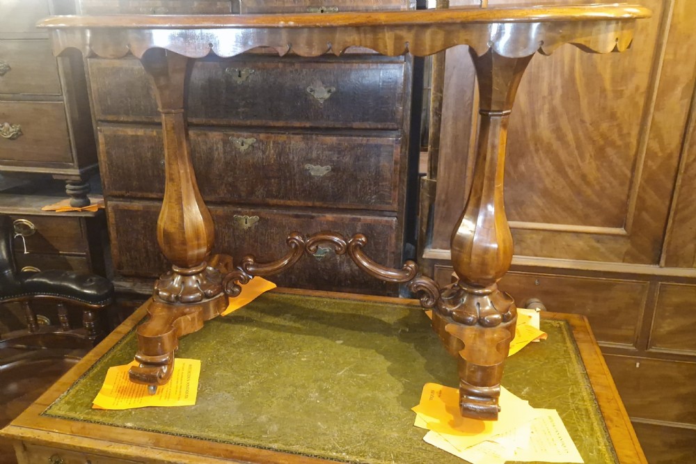 A mid-19th-century mahogany kidney-shaped side table featuring turned pedestal supports, a carved scrolled stretcher, and shaped feet. View XI