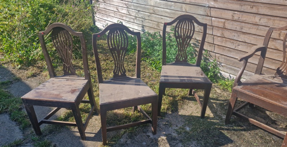 A set of eight antique brown wooden country dining chairs featuring carved pierced splat backs and solid timber panel seats. View V