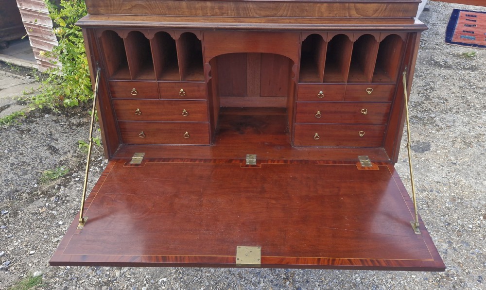 An antique mahogany bureau cabinet featuring an upper cupboard with panelled doors above a drop-front writing desk with fitted pigeonholes and drawers. View XIII