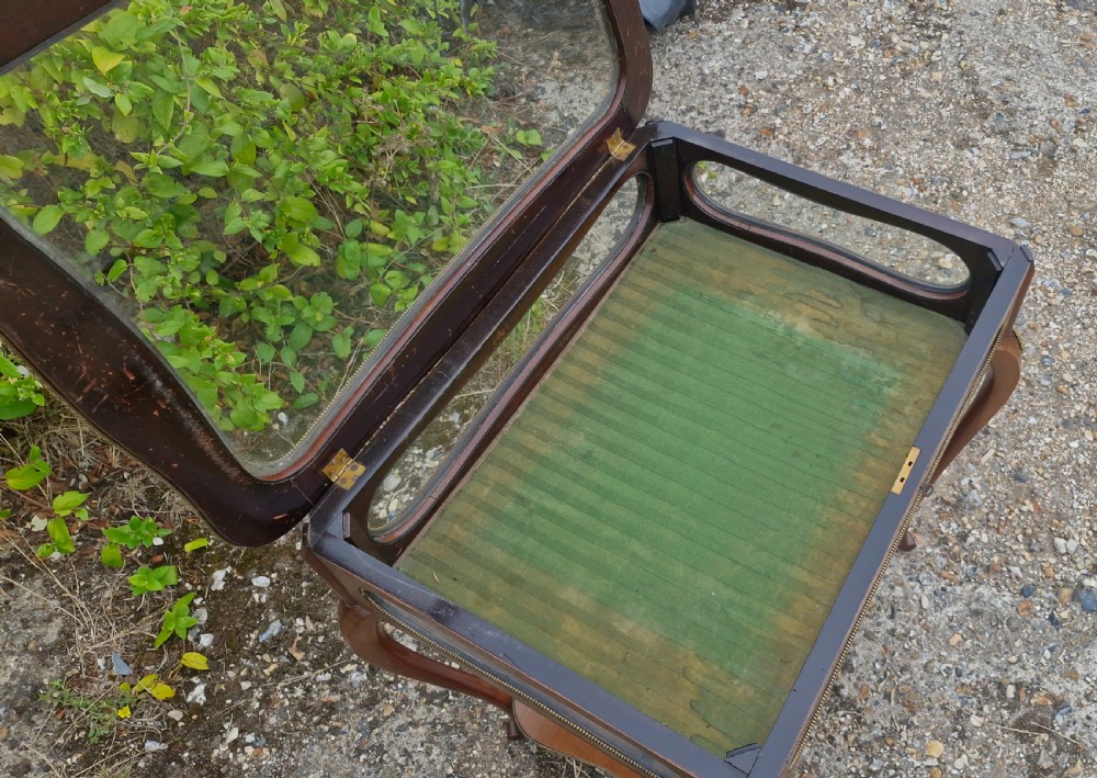 An Edwardian mahogany bijouterie table featuring floral marquetry inlay on the hinged glass top, slender cabriole legs, brass mounts, and a green fabric-lined interior. View II