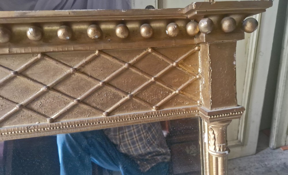 A 19th-century rectangular giltwood overmantel mirror featuring a lattice frieze, ball moulding along the top cornice, and flanking fluted columns. View II